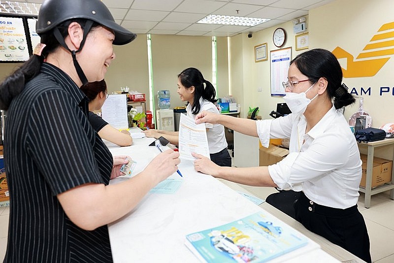 Giao dịch viên của Bưu điện Việt Nam tư vấn cho khách hàng về thông tin chương trình Khuyến mại nhân Kỷ niệm 15 năm Thành lập Ngân hàng TMCP Bưu điện Liên Việt