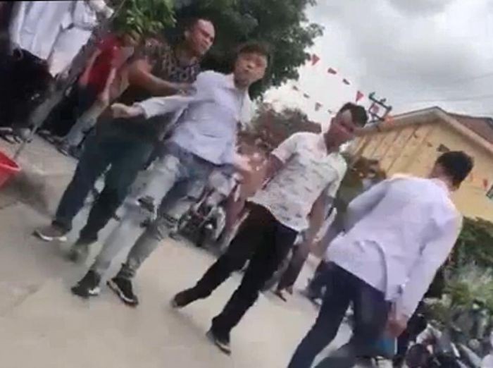 Hai người đàn ông đánh nam sinh lớp 11. (Ảnh trích xuất từ video)