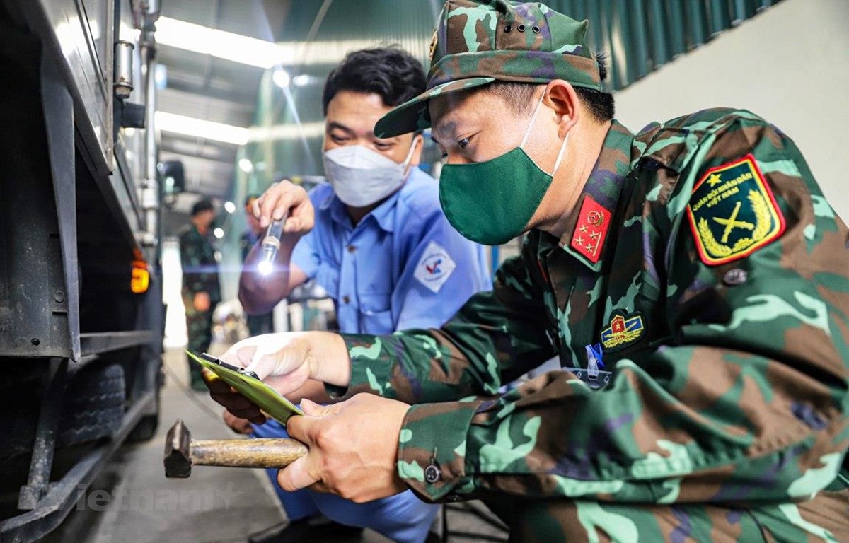 Kiểm tra giấy chứng nhận đăng kiểm của phương tiện đến kiểm định. (Ảnh: Hoài Nam/Vietnam+)