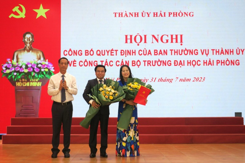 Ông Đỗ Mạnh Hiến - Phó Bí thư Thường trực Thành ủy trao quyết định, tặng hoa chúc mừng tân Bí thư Đảng ủy, tân Hiệu trưởng Đại học Hải Phòng