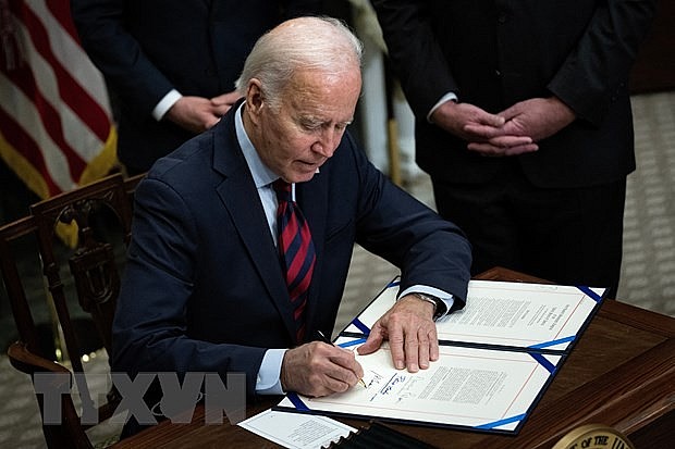 Tổng thống Mỹ Joe Biden ký một văn kiện tại Nhà Trắng, Washington, DC. (Ảnh: AFP/TTXVN)