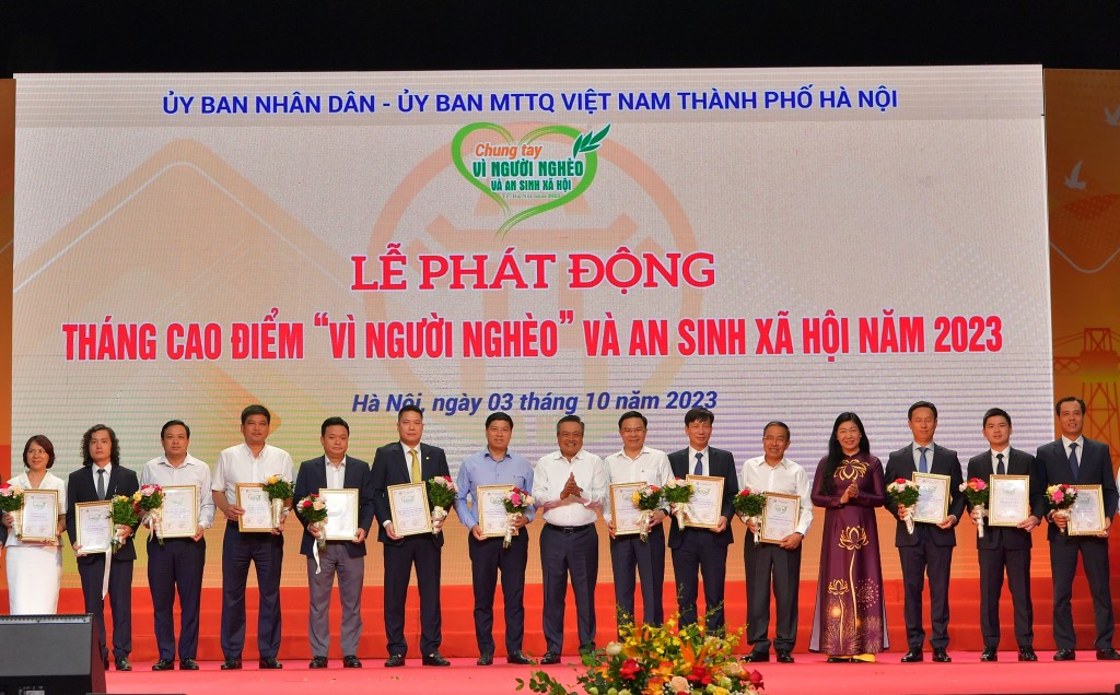 Đồng chí Trần Sỹ Thanh - Ủy viên Trung ương Đảng, Chủ tịch Ủy ban nhân dân thành phố Hà Nội (thứ 8 từ phải sang) và đồng chí Nguyễn Lan Hương - Chủ tịch Ủy ban MTTQ Việt Nam Tp. Hà Nội (thứ 4 từ phải sang) chụp ảnh lưu niệm cùng đồng chí Hồng Quang - Thàn