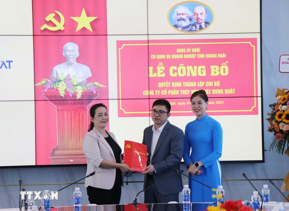 Bà Đinh Thị Hồng Minh (trái), Phó Bí thư Tỉnh ủy Quảng Ngãi trao Quyết định Bí thư Chi bộ Công ty Cổ phần Thép Hòa Phát Dung Quất cho ông Lưu Thanh Tùng. (Ảnh: Phạm Cường/TTXVN)