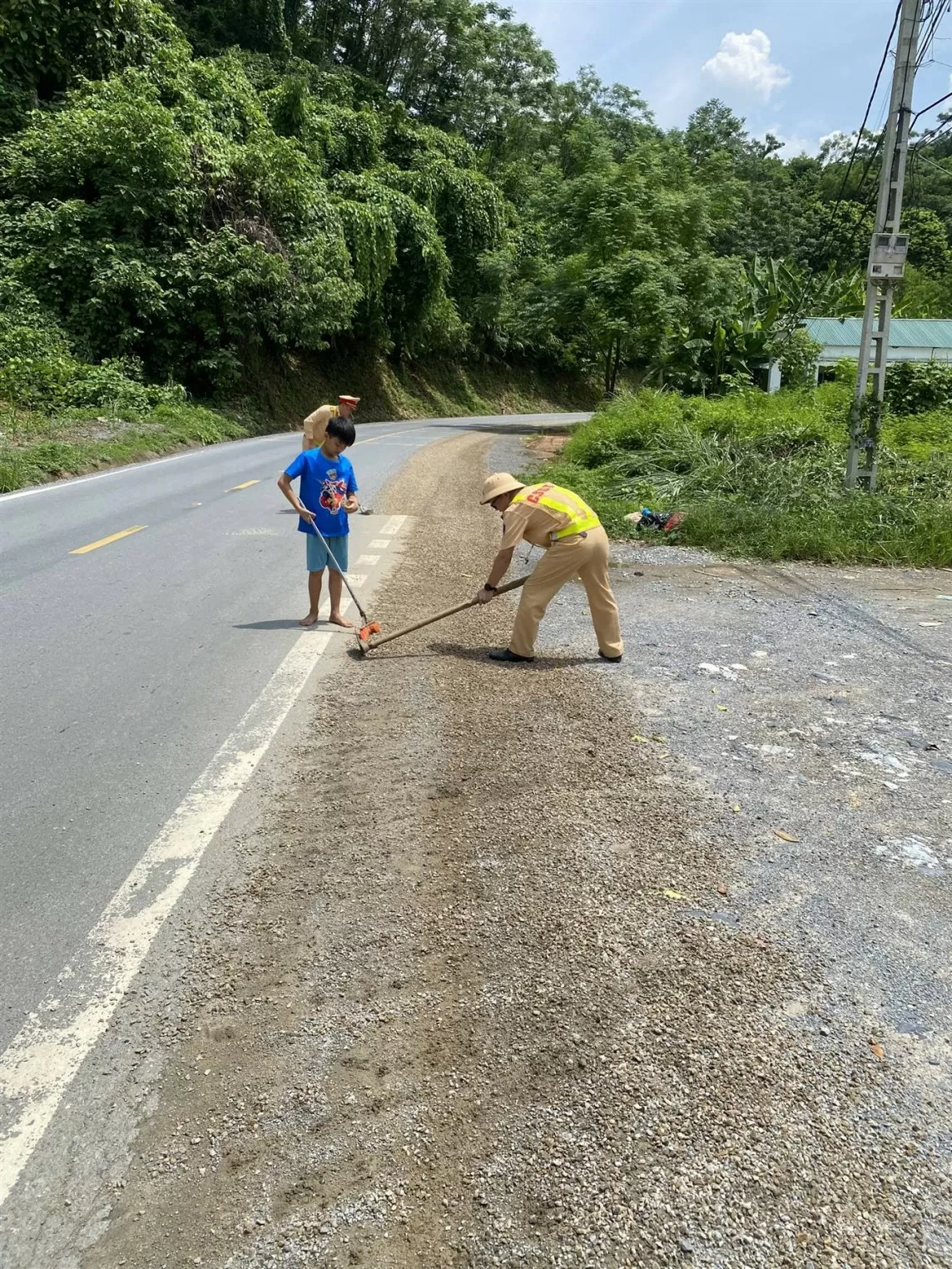 Lào Cai: Cảnh sát giao thông dọn đá trên mặt đường giúp người dân đi lại an toàn