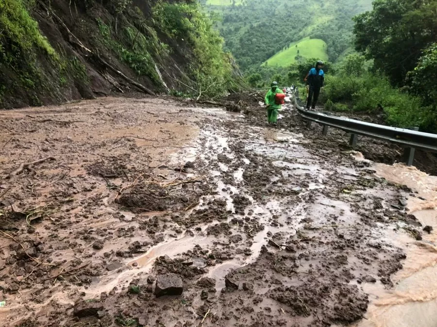 Sạt lở khiến giao thông ở nhiều tuyến đường bị tê liệt, người dân chỉ có thể đi bộ qua.