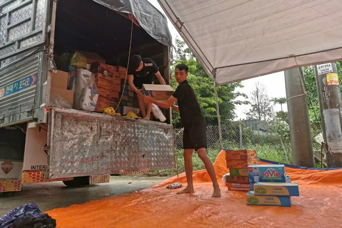 Từ sáng sớm, anh Dũng cùng nhóm bạn trẻ tất bật chuyển đổ, phân loại để nhanh nhất có thể đến được với bà con vùng lũ (Ảnh: Bảo An).