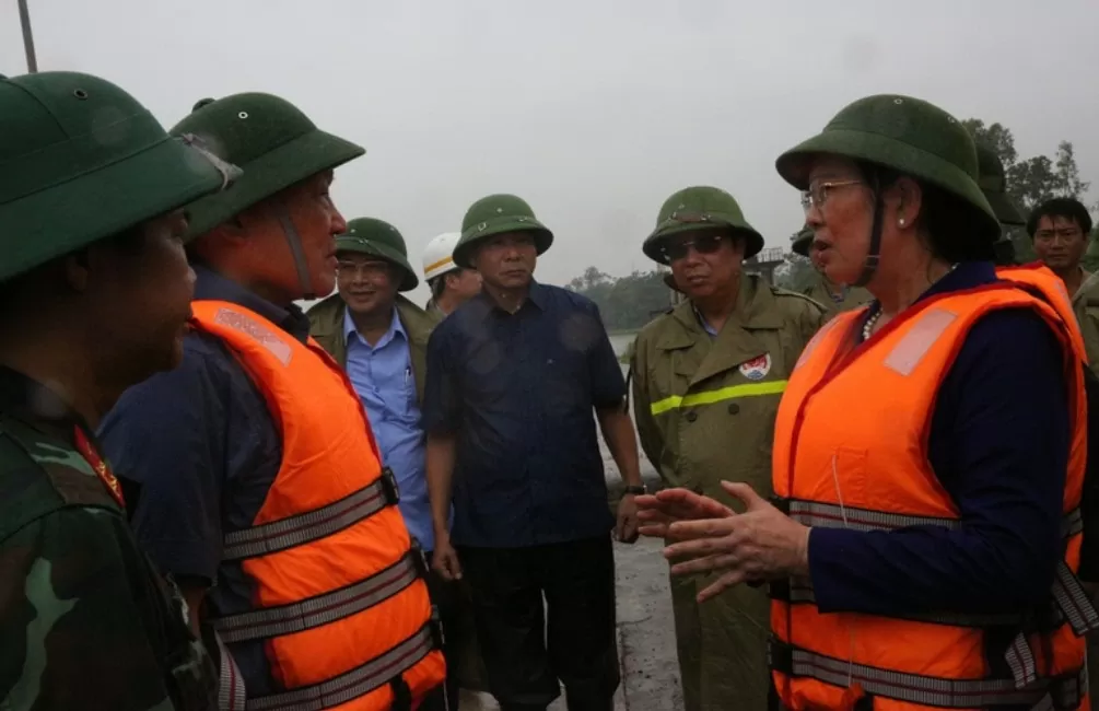 Phó Thủ tướng Thường trực Chính phủ Nguyễn Hòa Bình nghe Bí thư Tỉnh ủy Hà Nam Lê Thị Thủy báo cáo khi đi thị sát. (Ảnh: VGP/Nguyễn Hoàng)