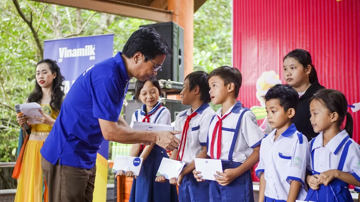 Ông Lê Hoàng Minh, Giám đốc Điều hành sản xuất Vinamilk, trao học bổng cho học sinh khó khăn tại xã Đất Mũi, tỉnh Cà Mau nhân dịp trung thu