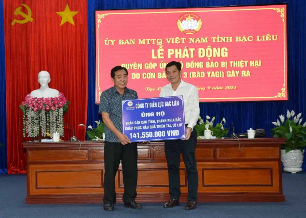 Ông Trần Hữu Khoa - Giám đốc Công ty Điện lực Bạc Liêu (người đứng bên phải) trao tiền ủng hộ khắc phục thiệt hại do bão số 3. Ảnh PC Bạc Liêu