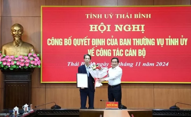 Phó Bí thư Thường trực Tỉnh ủy, Chủ tịch HĐND tỉnh Thái Bình Nguyễn Tiến Thành (bìa phải) trao quyết định, tặng hoa chúc mừng tân Phó Trưởng ban Tổ chức Tỉnh ủy Nguyễn Duy Chiến. Ảnh: Thaibinh.gov.vn