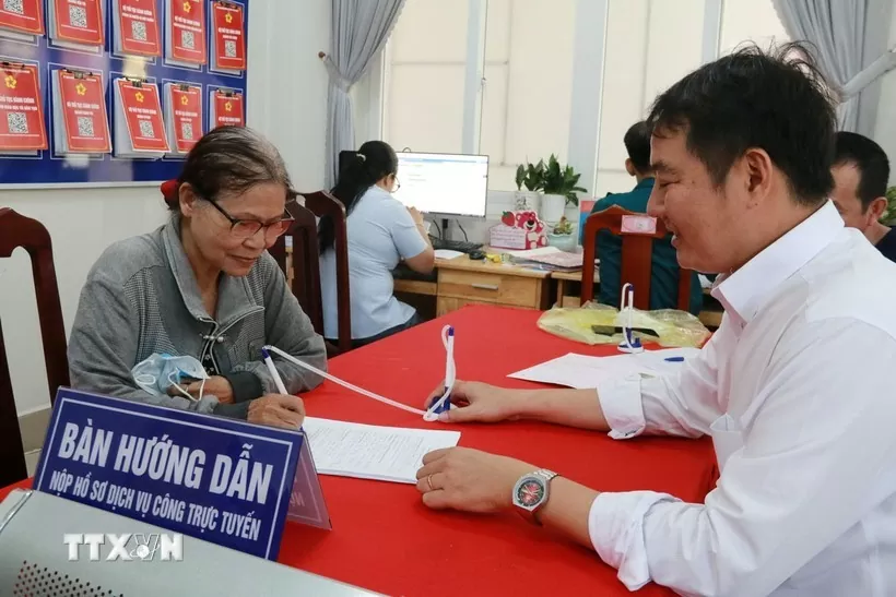 Người dân đến thực hiện thủ tục hành chính được cán bộ viên chức phường Tân Phong, thành phố Biên Hòa, hướng dẫn nhiệt tình. Ảnh: TTXVN