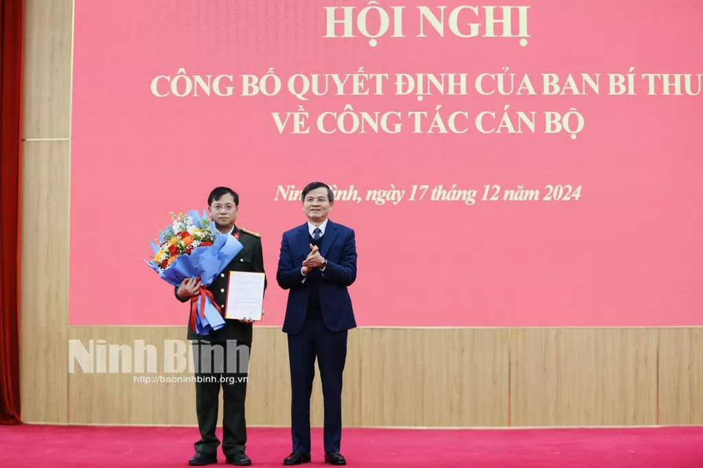 Bí thư Tỉnh uỷ Ninh Bình Đoàn Minh Huấn trao Quyết định, tặng hoa chúc mừng Đại tá Đinh Việt Dũng. Ảnh: Báo Ninh Bình