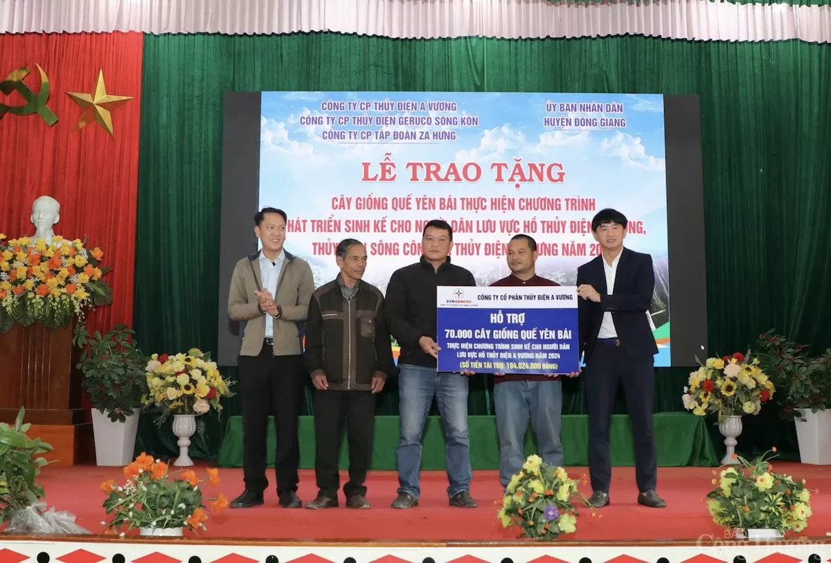 Ông Đinh Văn Bảo - Phó Bí thư Thường trực HU, Phó Chủ tịch UBND huyện Đông Giang (ngoài cùng bên trái), ông Võ Trà Dũng - Thành viên HĐQT Công ty CP Thủy điện A Vương (ngoài cùng bên phải) trao bảng tượng trưng tại buổi lễ