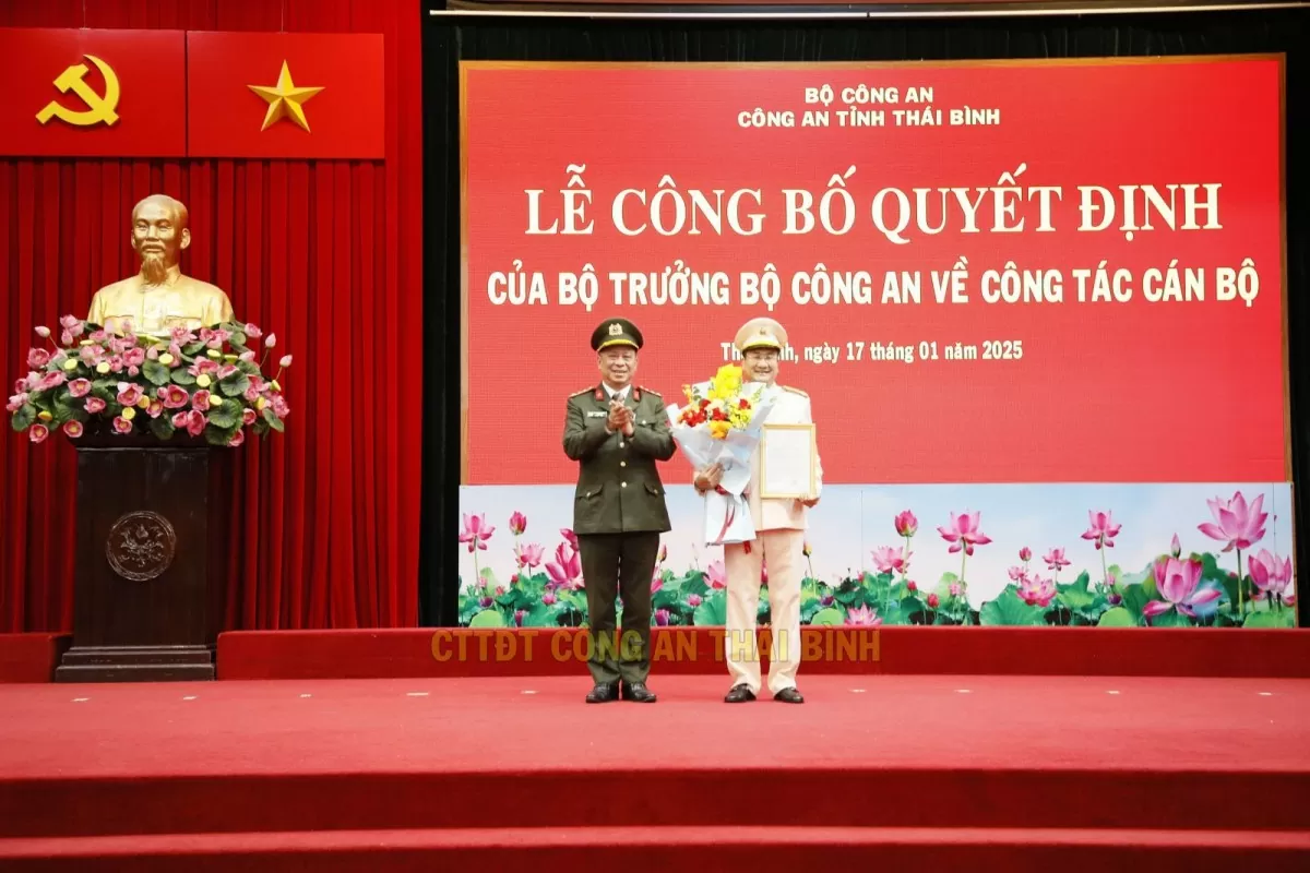 Đại tá Trần Xuân Ánh - Giám đốc Công an tỉnh Thái Bình trao quyết định, tặng hoa chúc mừng thượng tá Phạm Thanh Tiến.
