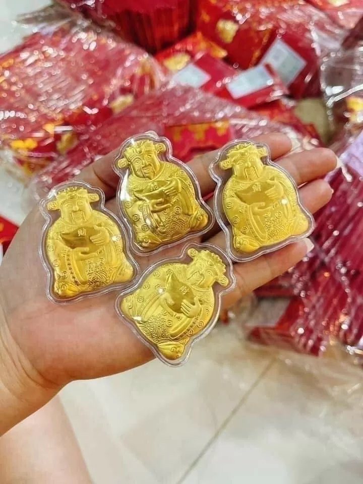 mỗi hình ông Thần tài đính kèm trong bao lì xì được làm từ hợp kim mỏng và phủ nhũ vàng bắt mắt. Ảnh: Nguyễn Vân