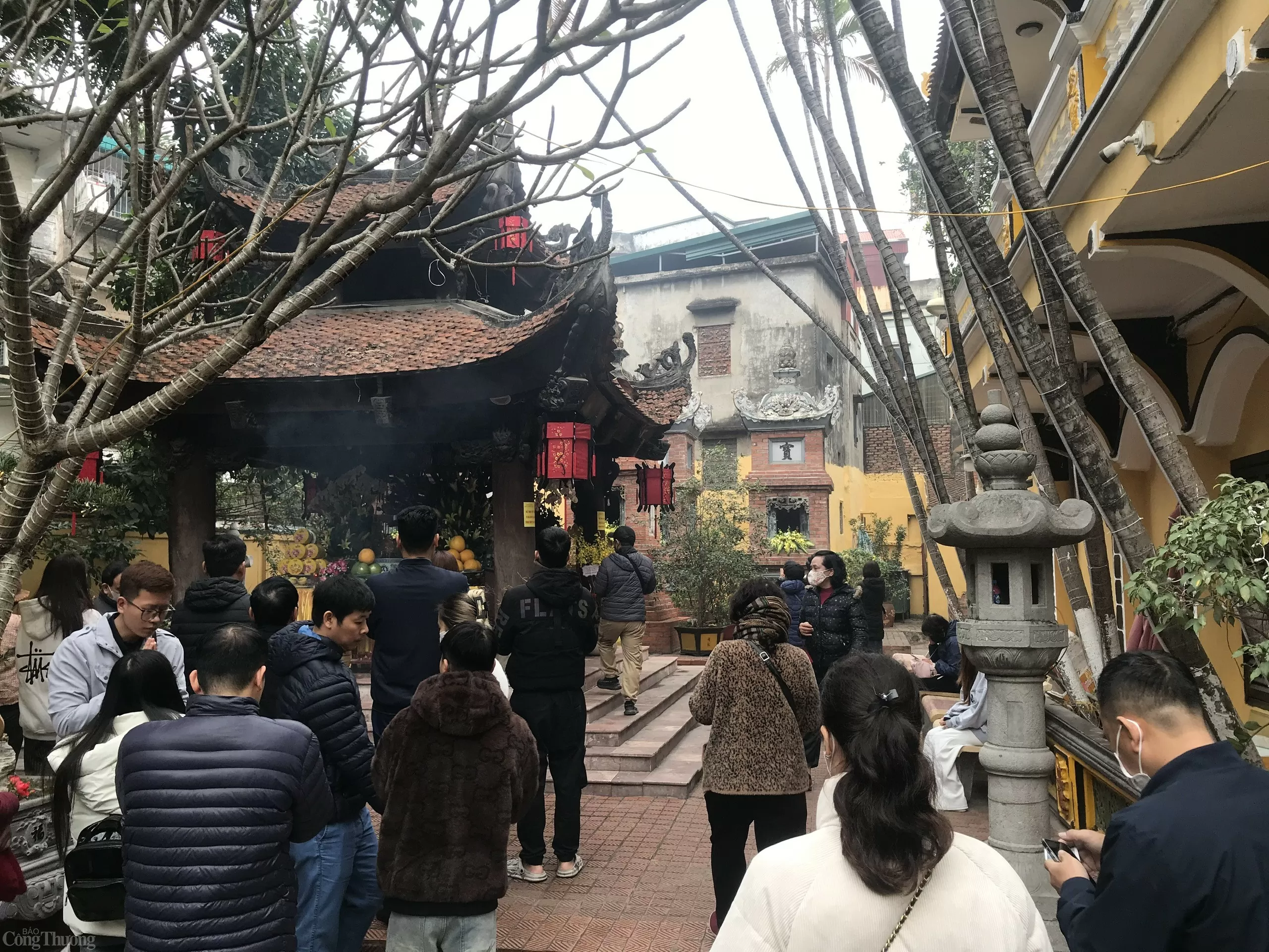 Từ xa xưa, dân gian có câu “Cúng quanh năm không bằng rằm tháng giêng”. Điều đó cho thấy về giá trị của ngày này. Trong đạo Phật, Tết Nguyên tiêu là ngày lễ quan trọng, các phật tử tin rằng ngày rằm tháng giêng là ngày mà ánh sáng từ bi của Phật có pháp lực mạnh mẽ, phổ chiếu nhân gian. Còn trong Đạo giáo mà người Việt chịu một phần ảnh hưởng, lễ cúng rằm tháng giêng còn được gọi là lễ Thượng nguyên. Do đó, ngay từ sáng 12/12 (ngày Rằm tháng Giêng), người dân đã không quản ngại cơn mưa phùn nặng hạt, trời giá lạnh để đến chùa Phúc Khánh (phố Tây Sơn, Hà Nội) để thắp hương, cầu bình an. Ảnh: Lê An