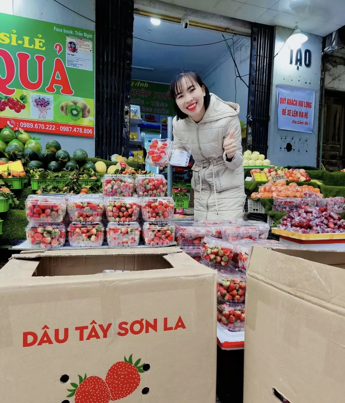 Tiểu thương bán dâu tây Sơn La tươi cười giới thiệu sản phẩm cho khách. Ảnh: Nguyễn Thanh
