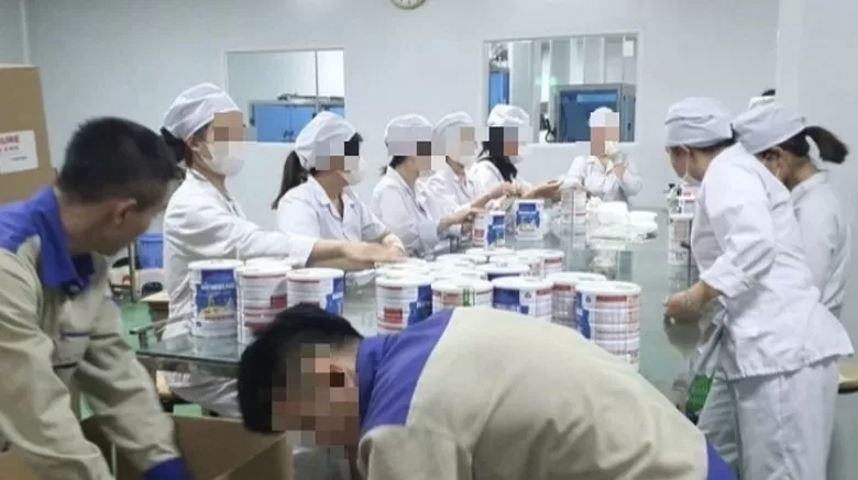 Công nhân đóng hộp thành phẩm tại cơ sở sản xuất sữa bột giả quy mô lớn vừa bị Công an thành phố Hà Nội triệt phá. (Ảnh: Báo Công an nhân dân)