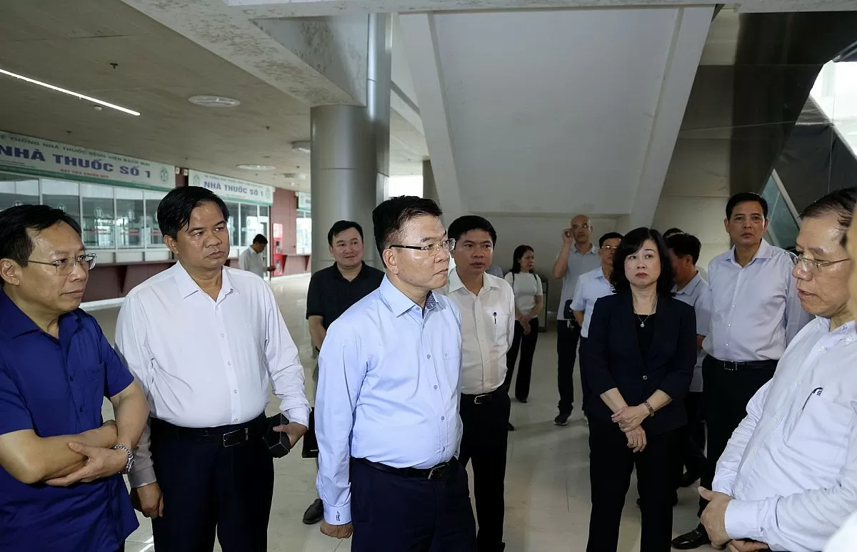 Phó Thủ tướng Lê Thành Long nghe Trưởng Ban quản lý Dự án báo cáo tình hình thi công Cơ sở 2 Bệnh viện Bạch Mai - Ảnh: VGP/Đức Tuân