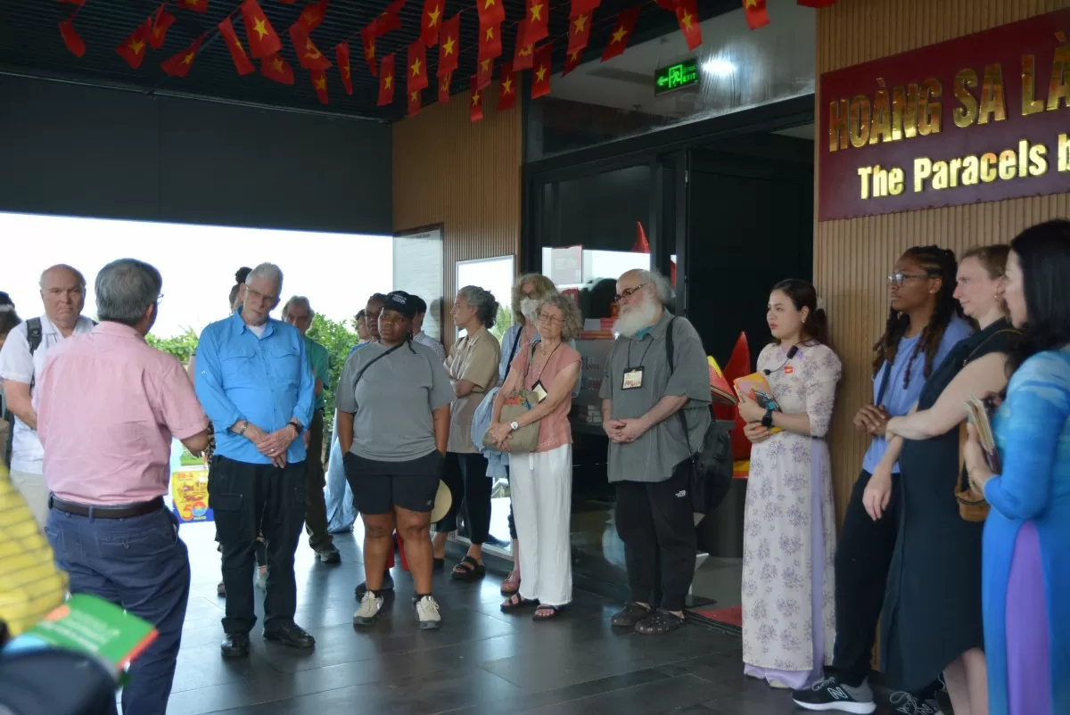 Du khách nước ngoài lắng nghe thuyết minh viên giới thiệu về chủ quyền biển đảo Việt Nam. Ảnh: Ngọc Thảo