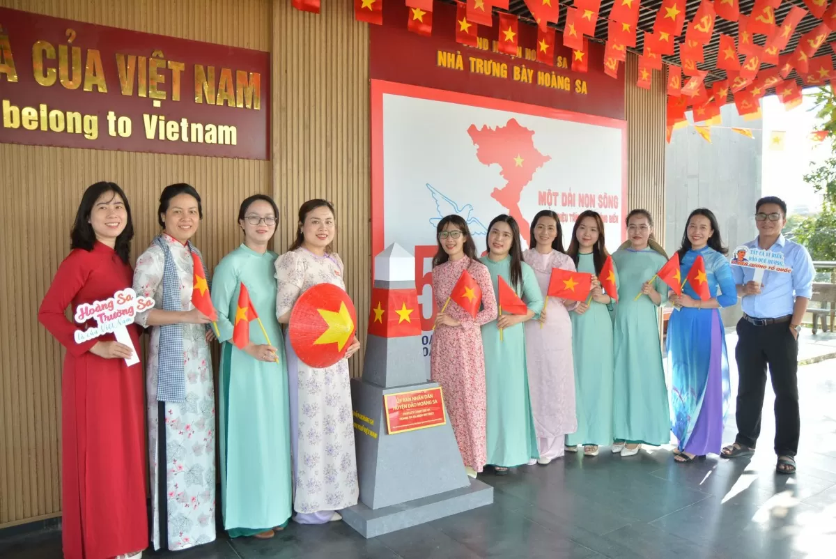 Những bộ áo dài truyền thống cùng cờ Tổ quốc trở thành điểm nhấn trong những bức ảnh check-in của du khách. Ảnh: Ngọc Thảo