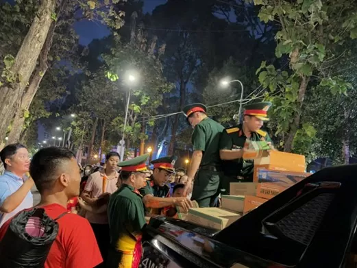 Ấm lòng các chiến sĩ phát lương khô cho người dân – Ảnh: Hồng Duyên
