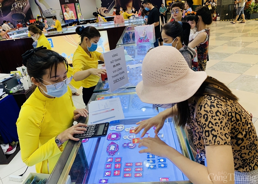 Người dân đeo khẩu trang, xếp hàng chờ tới lượt mua vàng ngày Thần tài