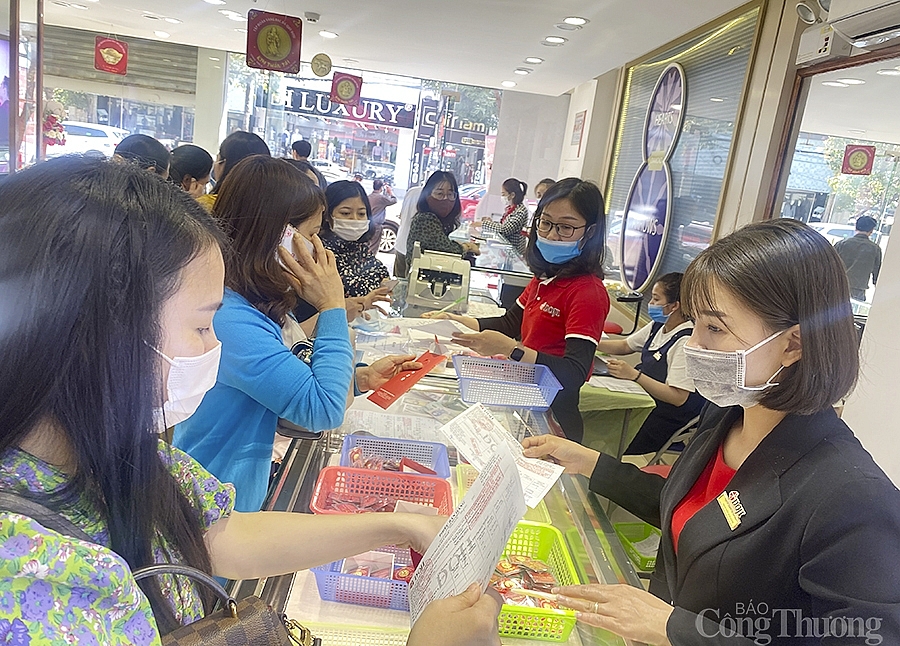 Người dân đeo khẩu trang, xếp hàng chờ tới lượt mua vàng ngày Thần tài