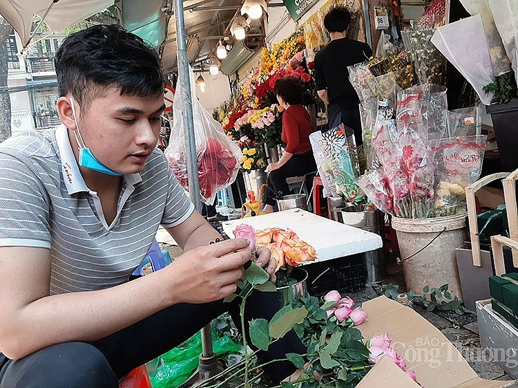 Người bán hàng lựa hoa để chuẩn bị cho việc cắm lên lẵng