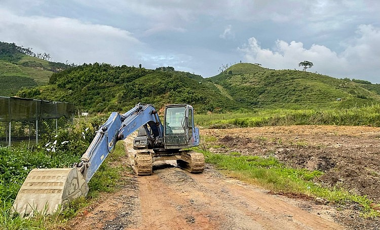 Máy múc chắn ngang đường để cản trở phương tiện tiếp cận bãi khai thác.