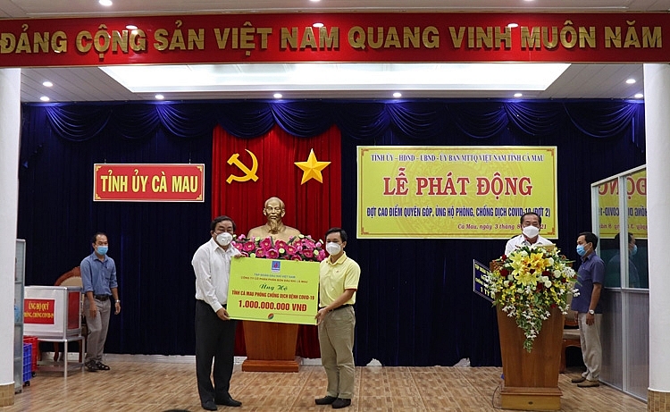 Anh Nguyễn Thanh Tùng (bìa phải) trao biển tượng trưng cho ông Trần Văn Hiện – Chủ tịch MTTQVN tỉnh Cà Mau