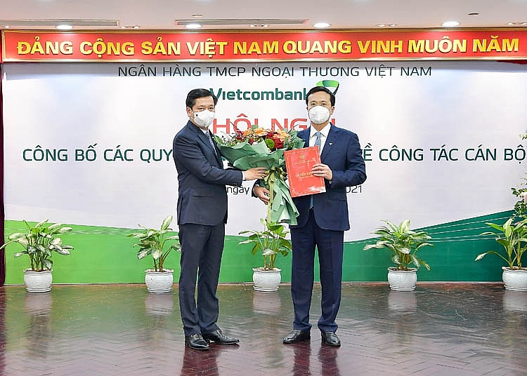 Đ/c Nguyễn Long Hải - Ủy viên dự khuyết BCH Trung ương Đảng, Bí thư Đảng ủy Khối Doanh nghiệp Trung ương (bên trái) trao quyết định và tặng hoa chúc mừng đ/c Phạm Quang Dũng - Ủy viên Ban Chấp hành Đảng bộ Khối DNTW, tân Bí thư Đảng ủy Vietcombank