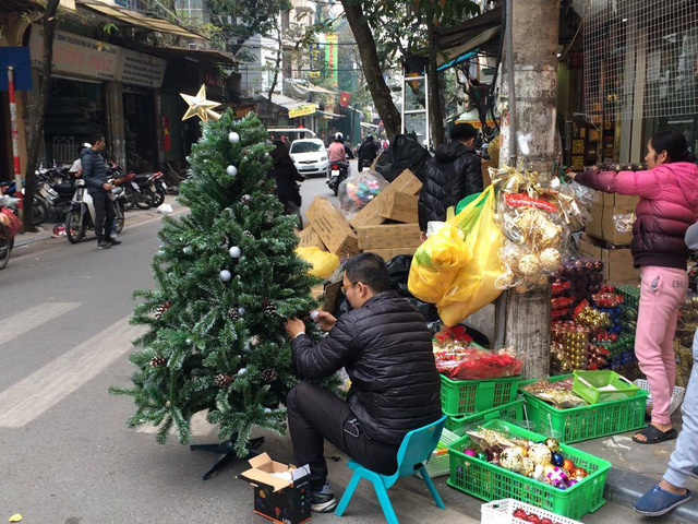 Những người bán hàng trang trí cây thông theo yêu cầu khách hàng.