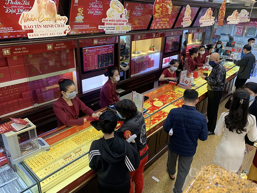 Người dân đeo khẩu trang, xếp hàng chờ tới lượt mua vàng ngày Thần Tài