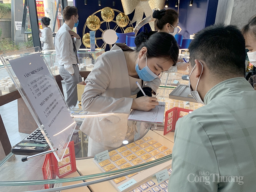 Người dân đeo khẩu trang, xếp hàng chờ tới lượt mua vàng ngày Thần Tài